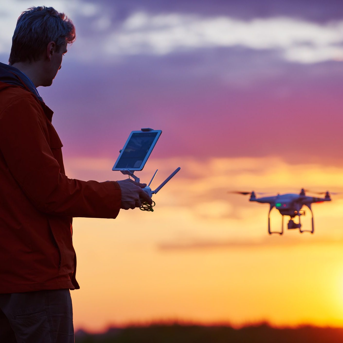 Man Flying Drone at Sunset